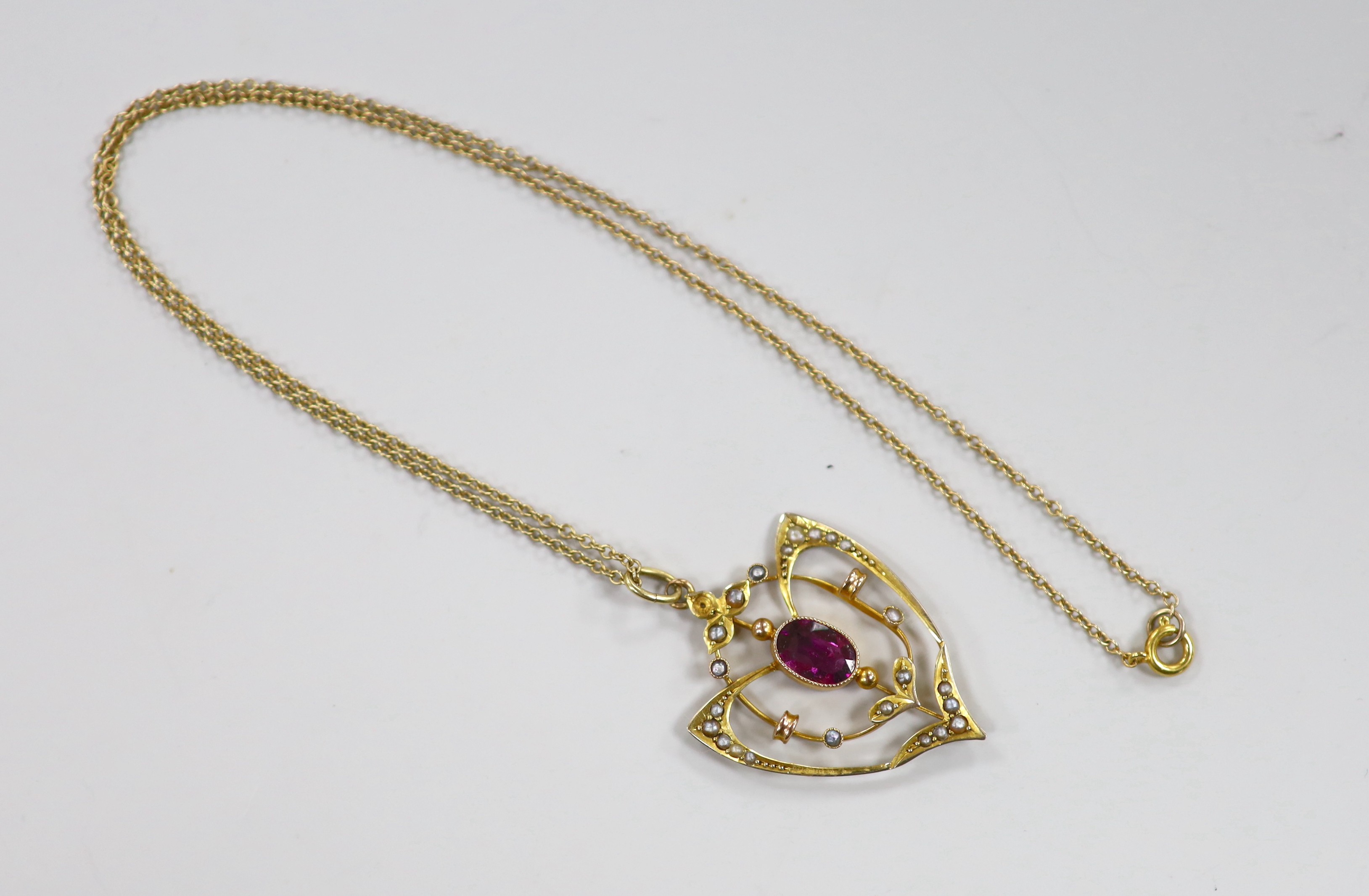 An Edwardian 9ct, garnet and seed pearl cluster set pendant, 33mm, on a later 9ct chain, 39cm, gross weight 3.7 grams.